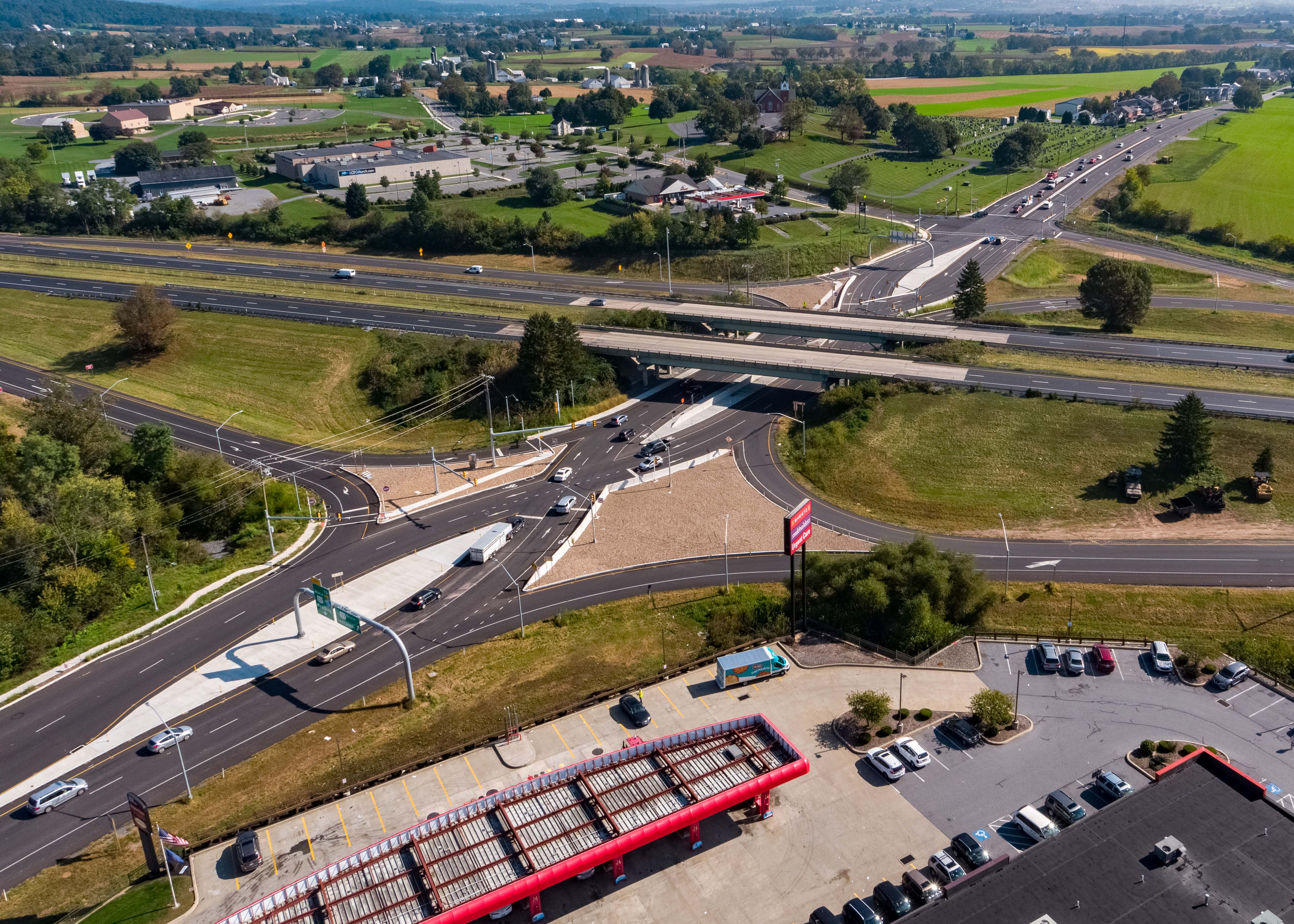 An aerial image of the newly constructed Diverging Diamond Interchange at 322/222, showing how crossroad traffic in both directions is transitioned or crossed over to the left side at a signal-controlled point and then transitioned back to the right side at a second signal-controlled point after passing through the interchange